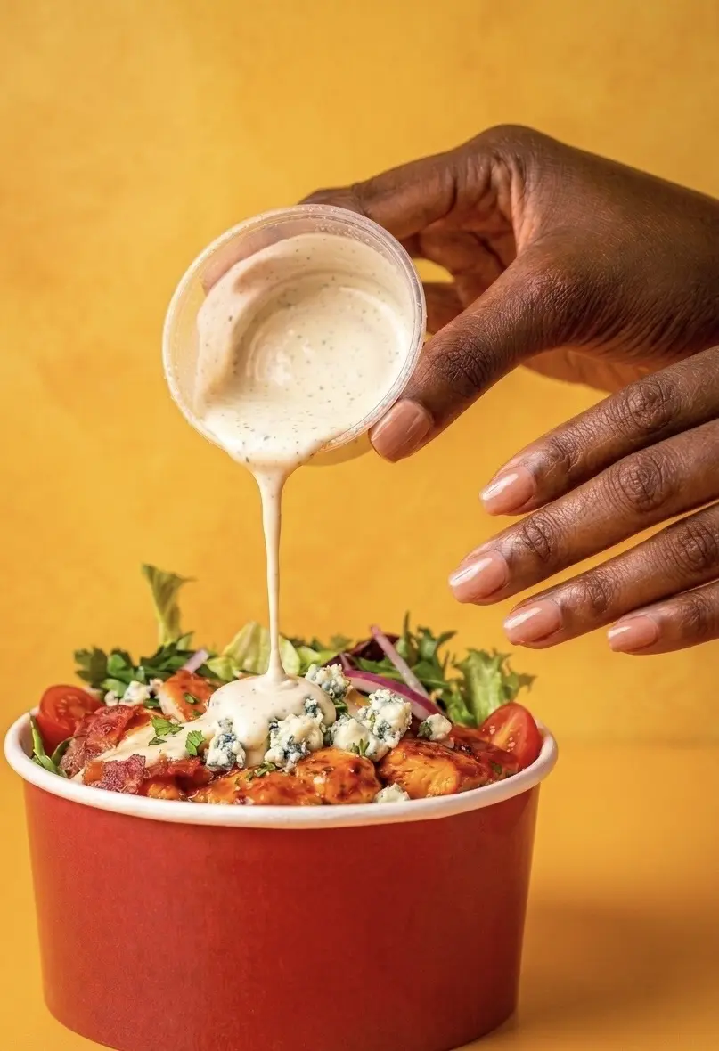 Dressing poured over a fresh salad